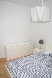 a white bedroom with a bed and a white dresser at Koidula Villa in Pärnu
