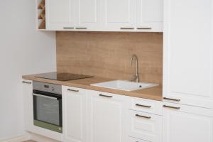 a kitchen with white cabinets and a sink at Koidula Villa in Pärnu