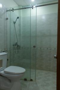 a bathroom with a glass shower with a toilet at Paradise Hotel in Hoi An