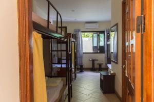 a room with bunk beds and a hallway with a table at Paradise Hotel in Hoi An