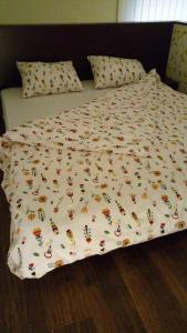 a bed with a white comforter with bugs on it at Laura Studio - Central in Oradea