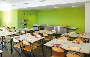 a classroom with tables and chairs and green walls at JF Accueil & Formation in Cholet