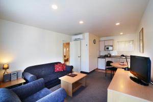 a living room with a couch and a tv at Siena Motor Lodge in Whanganui