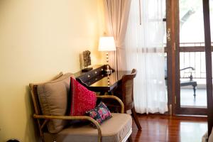uma sala de estar com uma cadeira e uma secretária em Villa Klang Wiang em Chiang Mai