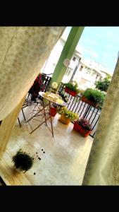 a balcony with a table and chairs and potted plants at B&B L'angolo fiorito in Bernalda