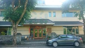 a car parked in front of a building at Chong Er Ya She Homestay in Jiji