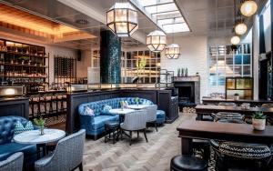 um restaurante com sofás e mesas azuis e um bar em The River Lee Hotel a member of The Doyle Collection em Cork
