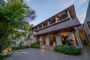 an exterior view of a building with palm trees at Villa Klang Wiang in Chiang Mai