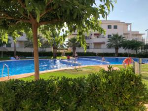 a swimming pool with people playing in the water at Ático en el mar in Alcossebre