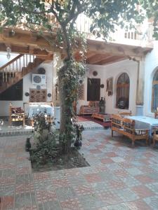 una sala de estar con un árbol en el medio en Hotel Nazira & Azizbek, en Bukhara