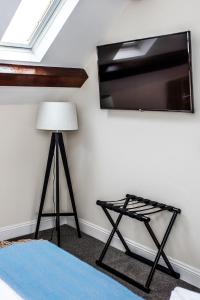 Zimmer mit einer Lampe und einem TV an der Wand in der Unterkunft The Black Boy Inn in Caernarfon