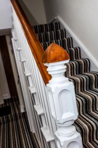 a white stair case with a white rail and a staircase with at The Black Boy Inn in Caernarfon