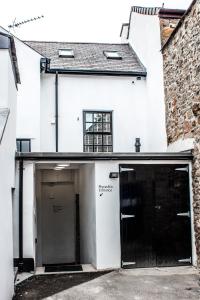 een wit gebouw met twee garagedeuren en een raam bij The Black Boy Inn in Caernarfon