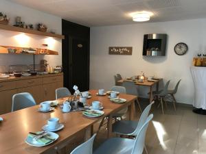 a dining room with tables and chairs and a kitchen at Waldpension Bielefeld in Bielefeld
