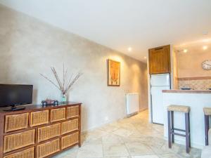 a living room with a television and a kitchen at Apartment Les Carles by Interhome in Saint-Tropez
