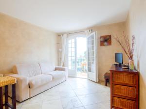 un salon avec un canapé blanc et une télévision dans l'établissement Apartment Les Carles by Interhome, à Saint-Tropez