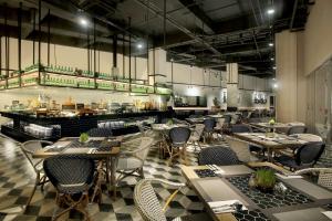a restaurant with tables and chairs and a counter at The Zuri Hotel Palembang in Palembang