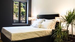 ペーゾ・ダ・レーグアにあるBugalha My Loft Douro 1のベッドルーム1室(白いシーツ付きのベッド1台、窓付)