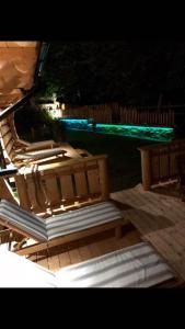 a group of benches sitting on a deck at night at Góralska Osada Karpacz - Apartametny in Karpacz