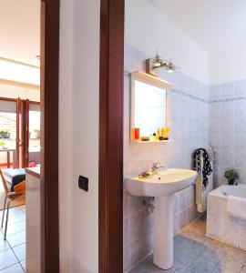 La salle de bains est pourvue d'un lavabo, d'une fenêtre et d'une baignoire. dans l'établissement 17 Lake Sweet Home, à Acquaseria