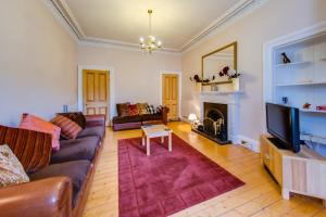 sala de estar con sofá y chimenea en ALTIDO Modern 3 bed flat, closeby the Meadows & Old Town en Edimburgo