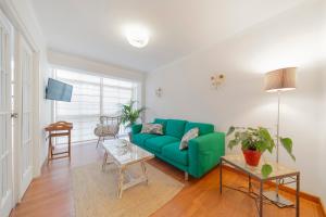 ein Wohnzimmer mit einer grünen Couch und einem Tisch in der Unterkunft Apartamento En El Centro De Nerja in Nerja