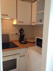 杜塞道夫的住宿－Messewohnung Düsseldorf-Nord，小厨房配有白色橱柜和微波炉