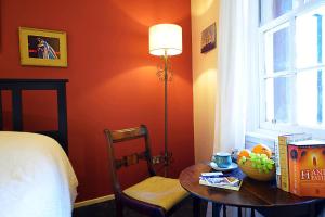 ein Schlafzimmer mit einem Tisch, einer Lampe und einem Bett in der Unterkunft ALTIDO Bohemian Writers Retreat in Heart of The Old Town in Edinburgh