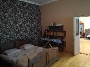 1 dormitorio con 1 cama y papel pintado con motivos florales en Keta House, en Tiflis