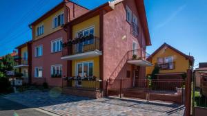 a large building with yellow and pink at Apartmány BOSS in Liptovský Mikuláš