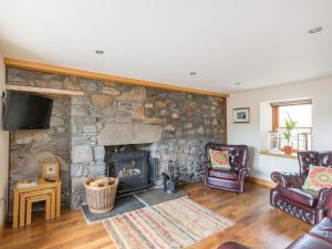 a living room with a stone wall with a fireplace at Cullen 117 Seatown With Sea Views in Cullen