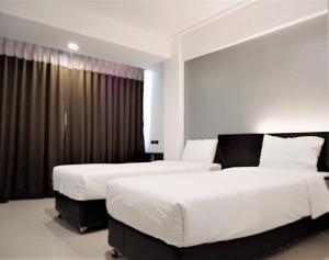 Postel nebo postele na pokoji v ubytování Izen Budget Hotel & Residence