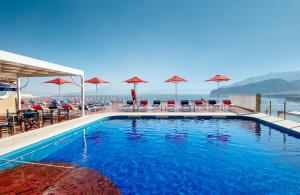 a swimming pool with chairs and umbrellas at Hotel Minerva in Sorrento