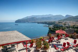 a view of a body of water with tables and chairs at Hotel Minerva in Sorrento