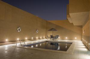 a pool in a room with lights on the wall at Al Muhaidb Al Takhasosi Hotel in Riyadh
