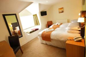 a hotel room with a large bed and a mirror at Rose And Crown in Porthcawl