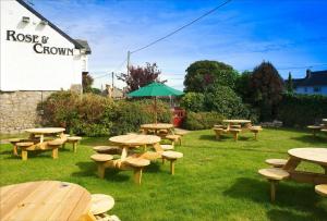 a group of picnic tables and benches in the grass at Rose And Crown in Porthcawl