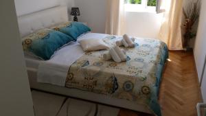 a bed with two stuffed animals sitting on top of it at APARTMENT "Patricia" in Split