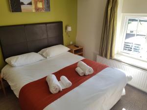 a bedroom with a bed with two towels on it at Rose And Crown in Porthcawl