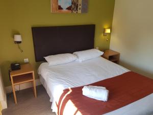 a bedroom with a large bed with two towels on it at Rose And Crown in Porthcawl