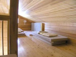 a room with two beds in a wooden room at Holiday Home Riitula by Interhome in Jokijärvi