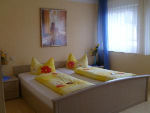 2 łóżka z poduszkami w sypialni w obiekcie StadtCafé Pension w mieście Grünstadt