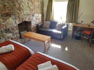 a living room with a couch and a fireplace at Rose And Crown in Porthcawl