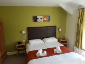 a bedroom with a bed with towels on it at Rose And Crown in Porthcawl