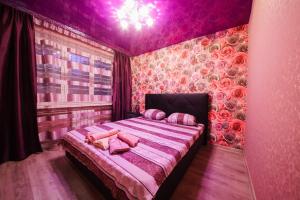 1 dormitorio con 1 cama en una habitación rosa en Nikolaevskie Apartments, en Saratov