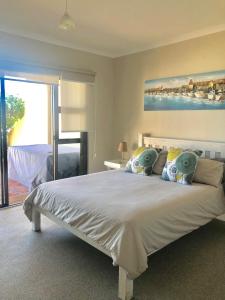 a bedroom with a large white bed with a window at Beachfront Apartment at Malata Beach in Blouberg in Bloubergstrand