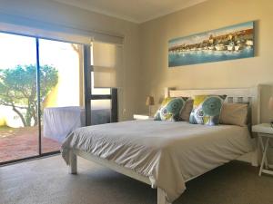 um quarto com uma cama branca e uma grande janela em Beachfront Apartment at Malata Beach in Blouberg em Bloubergstrand