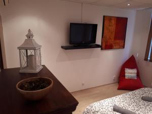 uma sala de estar com uma mesa e uma televisão na parede em Útulný apartmán v Bratislava 6 em Bratislava