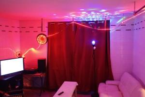 un soggiorno con tenda rossa e TV di Chambre centre Pleyber-Christ a Pleyber-Christ