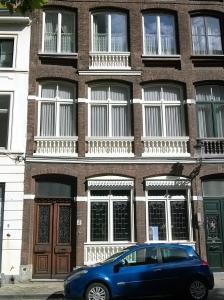 a blue car parked in front of a brick building at Boutique B&B Poppy's in Bruges